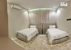 a room with two beds and a heater at شقق شهم المفروشه in Abha