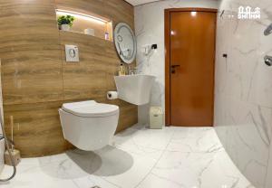 a bathroom with a white toilet and a sink at شقق شهم المفروشه in Abha +24 photos