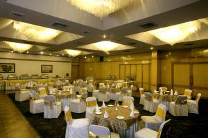 um salão de banquetes com mesas brancas e cadeiras brancas em ASIA The HERITAGE em Jamu