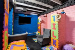a room with a playroom with a tv and chairs at Waterfront Escape Kayaks and Home in Gorokan