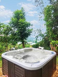 a hot tub sitting in the middle of a yard at Muangkham Cabin in Chiang Mai