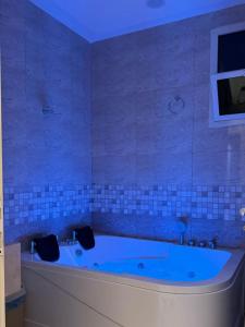 uma banheira azul numa casa de banho com azulejos azuis em ضيف بارك للأجنحة الفندقية em Ad Dawādimī