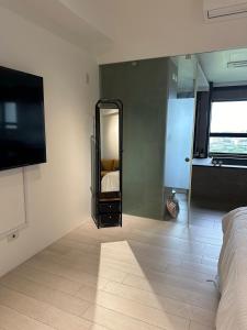頭城的住宿－幸福M&M House-龜山日出溫泉景觀宅，一间带镜子、一张床和电视的卧室