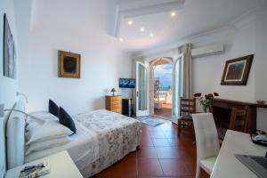 a bedroom with a bed and a table and a desk at Villa Briganti Seaview Terrace in Positano