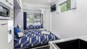 a small bedroom with a blue and white striped bed at Bella Cove in Bellara