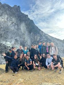 Un gruppo di persone che posano per una foto davanti a una montagna di Kaesa Homestay a Berastagi