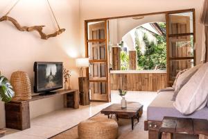 un soggiorno con un divano e una TV di Baan Yucca - House In Lamai a Nathon Bay