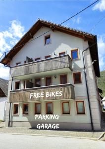 a white building with a parking garage sign on it at Apartments Bohinjc in Bohinj