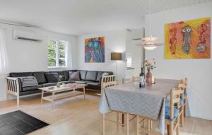 a living room with a table and a couch at Charming Cottage Close To The Beach in Vester Sømarken
