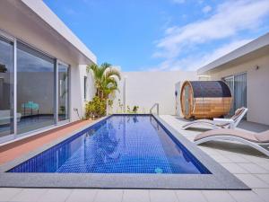 a swimming pool with a barrel next to a house at The Pool & Sauna Villa MOTOBU in Motobu
