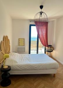 - une chambre avec un lit et une grande fenêtre dans l'établissement T2 Ajaccio vue mer, à Ajaccio