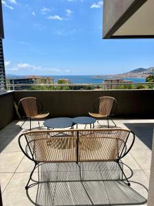 d'une terrasse avec 2 chaises et une table sur un balcon. dans l'établissement T2 Ajaccio vue mer, à Ajaccio