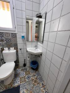 a bathroom with a toilet and a sink and a mirror at Downtown Sea View Suites in Alexandria