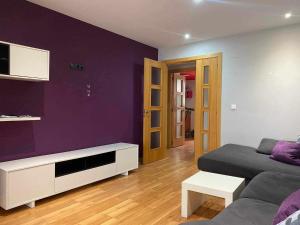 - un salon avec un lit et un mur violet dans l'établissement Puerto de Sagunt America 39, à Puerto de Sagunto
