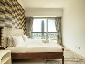 um quarto com uma cama e uma grande janela em Downtown Chic Easy walk to Dubai Mall & Fountain no Dubai