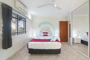 a bedroom with a bed with a painting on the wall at ZEN FORESHORE: 3-BR Nightcliff Foreshore-Front Apt in Nightcliff