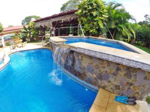 una piscina con una pared de piedra y agua azul en Hotel Esperanza, en Carrillo