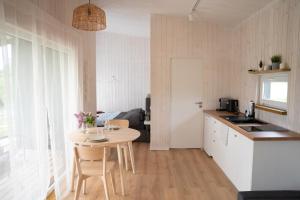 a kitchen with a table and a small kitchen with a table and chairs at Pineplace trio KOPA in Žaugėdai
