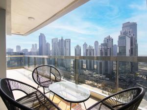 uma varanda com cadeiras e uma mesa e vista para a cidade em Downtown Chic Easy walk to Dubai Mall & Fountain em Dubai