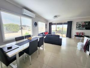 a living room with a table and chairs and a couch at Unit 51 Seafront Estate in Jurien Bay