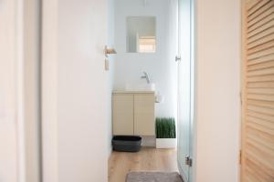 a white bathroom with a sink and a mirror at Pineplace trio KOPA in Žaugėdai