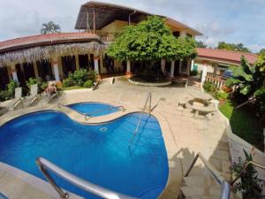 a swimming pool in front of a house at Hotel Esperanza in Carrillo