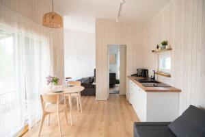 a kitchen and a living room with a table and a kitchen at Pineplace trio KOPA in Žaugėdai