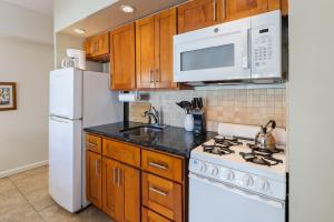 a kitchen with a stove and a white refrigerator at Waikiki Shore Beachfront in Honolulu