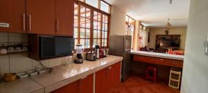 a kitchen with wooden cabinets and a large window at Casa de Campo Chinkay - Lunahuana in Lunahuaná