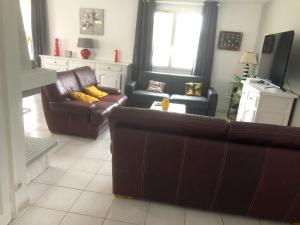 a living room with a couch and two chairs at Villa charmante à Saint-Georges-de-Didonne avec piscine privée. in Saint-Georges-de-Didonne