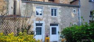 普瓦捷的住宿－Le CocoOn Doré，一座古老的石头房子,设有白色的门窗