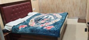 a bed with a blue blanket with flowers on it at Hotel Host near Taj in Agra
