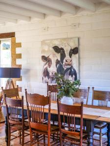 a dining room with a painting of a cow on the wall at Petana Farm Stay in Morton