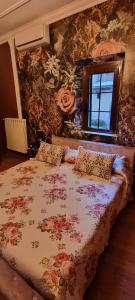 1 dormitorio con 1 cama grande con flores en la pared en Borgo Boutique Home, en Nettuno