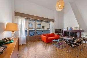 a living room with an orange chair and a couch at BoReal Apartments in Paradiso