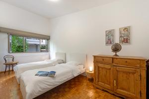 a bedroom with two beds and a wooden dresser at BoReal Apartments in Paradiso