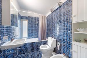 a blue tiled bathroom with a toilet and a sink at BoReal Apartments in Paradiso +38 photos