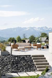 a patio with benches and mountains in the background at Chaletovo Mountain Residences in Zakopane