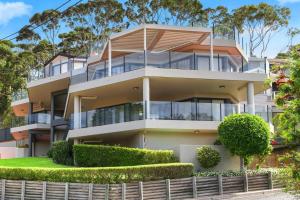 an apartment building with bushes in front of it at Spacious Modern Apartment with Breathtaking Views in Terrigal