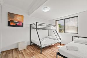 1 dormitorio con 2 literas y ventana en Spacious Modern Apartment with Breathtaking Views en Terrigal