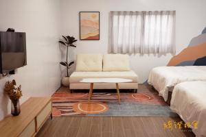 ein Wohnzimmer mit einem Sofa und einem TV in der Unterkunft 寮寓x綺澄 包棟宅 in Xiaoliuqiu