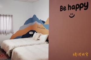 twee bedden in een kamer met een muurschildering van een berg bij 寮寓x綺澄 包棟宅 in Xiaoliuqiu