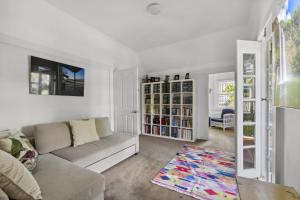 a living room with a couch and a book shelf at Poolside Stay - Close to Taronga Zoo & Luna Park in Sydney