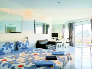 ein Schlafzimmer mit einem Bett und ein Wohnzimmer in der Unterkunft Sea View Beachfront Condos Pattaya Jomtien Beach in Jomtien Beach
