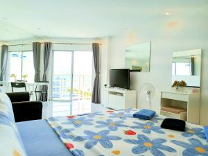 ジョムティエンビーチにあるSea View Beachfront Condos Pattaya Jomtien Beachの花柄の大型ベッドが備わるベッドルーム1室が備わります。