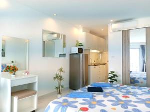 a kitchen and a bedroom with a bed and a refrigerator at Sea View Beachfront Condos Pattaya Jomtien Beach in Jomtien Beach