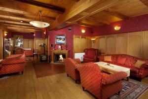 a living room with red furniture and a fireplace at Hotel Pod Jasany in Špindlerův Mlýn