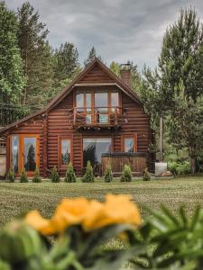 a log house with a porch and a yard at Poilsis netoli Druskininkų in Druskininkai