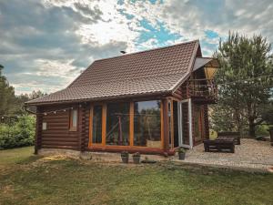 a log cabin with a large window and a deck at Poilsis netoli Druskininkų in Druskininkai