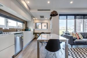 a kitchen and living room with a table and a couch at Professional living minutes from the city in Sydney